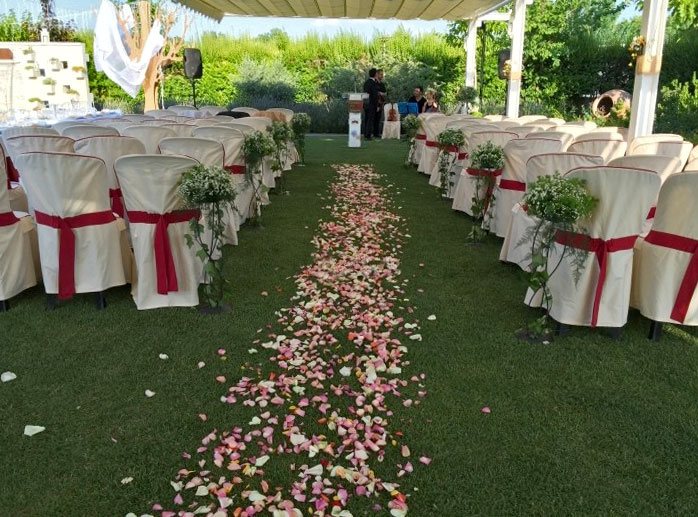 celebración de boda en un jardín con pétalos en el suelo