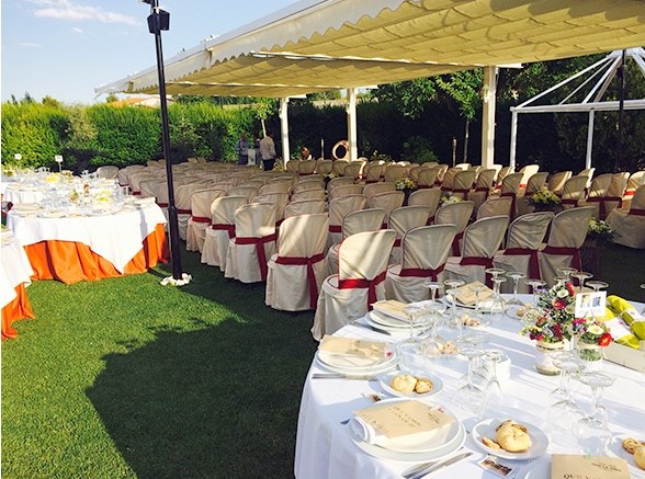 mesa y sillas blancas sobre jardín para bodas